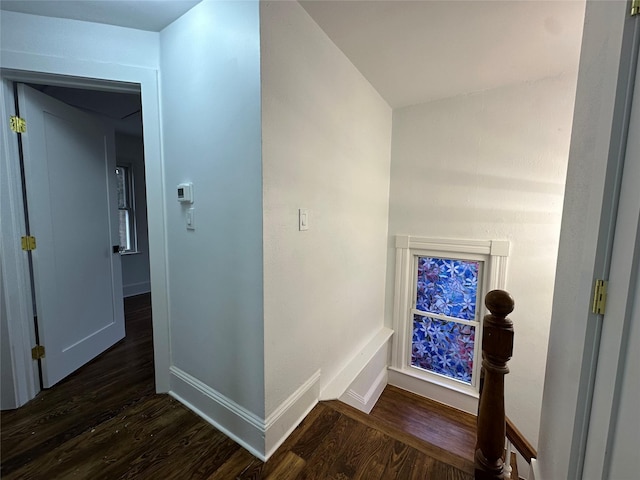 hall with dark wood-style flooring and baseboards