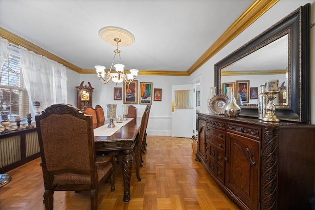 dining area with light parquet floors, crown molding, and an inviting chandelier