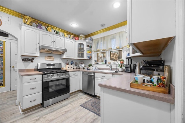 kitchen with white cabinetry, appliances with stainless steel finishes, crown molding, and light hardwood / wood-style flooring