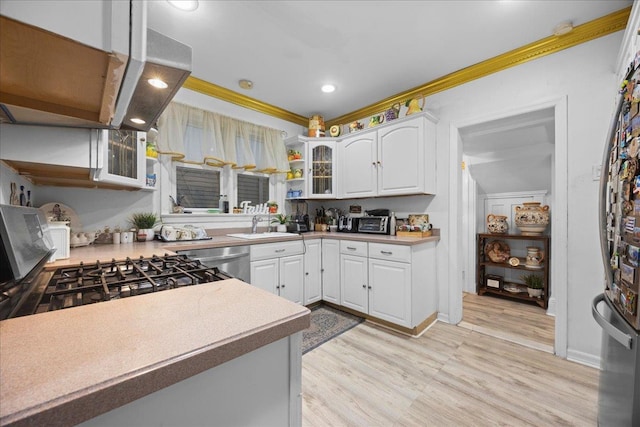 kitchen featuring sink, crown molding, white cabinets, stainless steel dishwasher, and light wood-type flooring