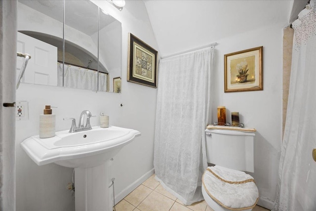 bathroom featuring tile patterned flooring, sink, lofted ceiling, and toilet