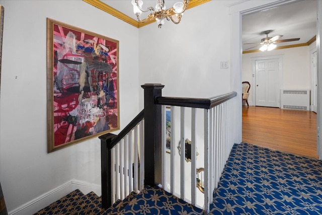 staircase with a chandelier, ornamental molding, radiator, and wood-type flooring