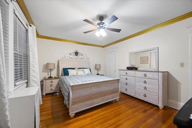 bedroom featuring dark hardwood / wood-style flooring, crown molding, and ceiling fan