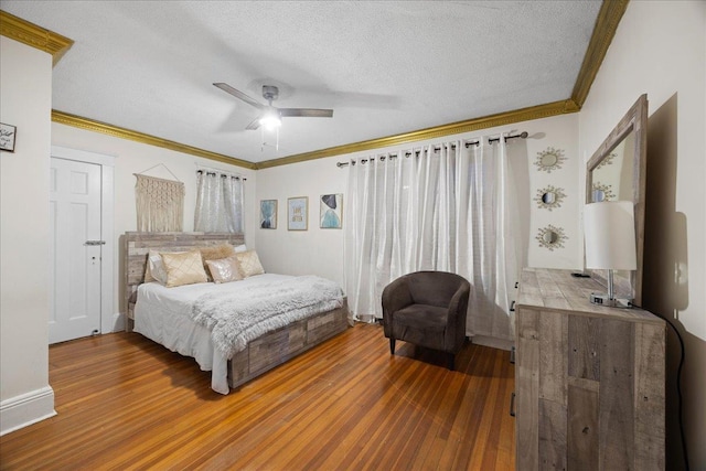 bedroom featuring hardwood / wood-style flooring, ornamental molding, and a textured ceiling