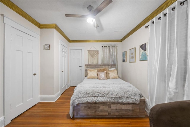 bedroom featuring crown molding, wood-type flooring, and ceiling fan