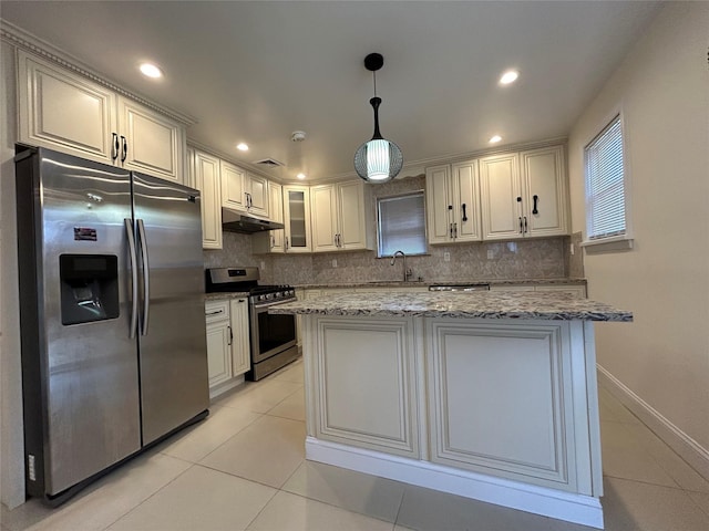 kitchen with light stone countertops, pendant lighting, appliances with stainless steel finishes, sink, and light tile patterned floors