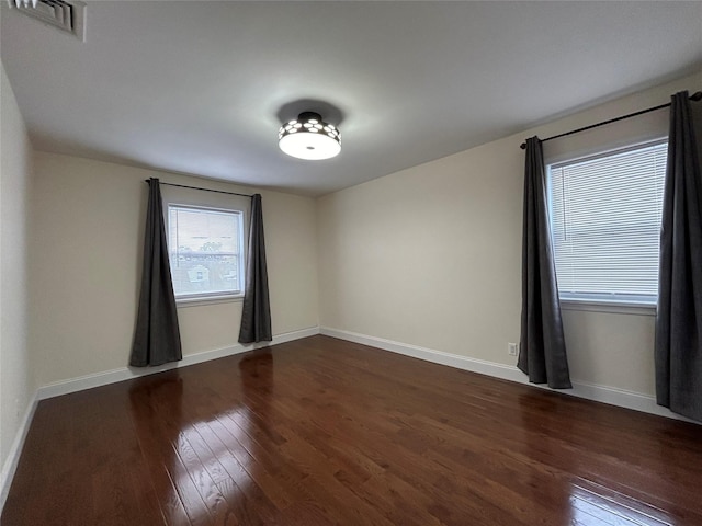 spare room with dark hardwood / wood-style floors