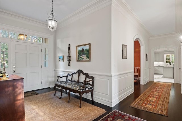 26 Morgan Ln, Locust Valley, NY 11560 - foyer entrance featuring ornamental molding, arched walkways, healthy amount of natural light, dark wood-style floors, and wainscoting