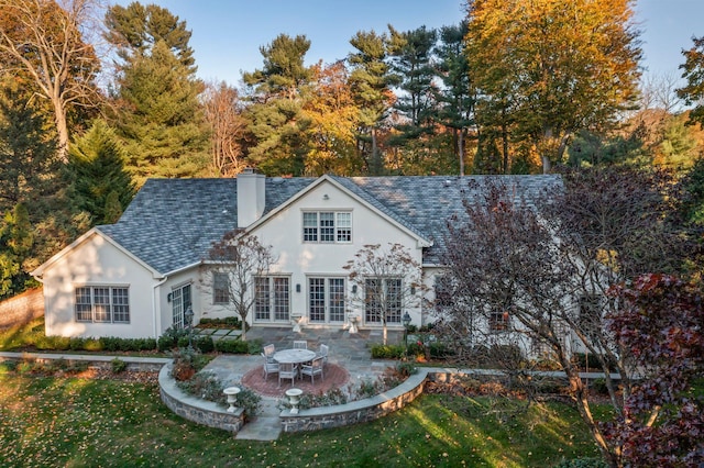 26 Morgan Ln, Locust Valley, NY 11560 - back of house featuring stucco siding, a chimney, a patio area, and a lawn