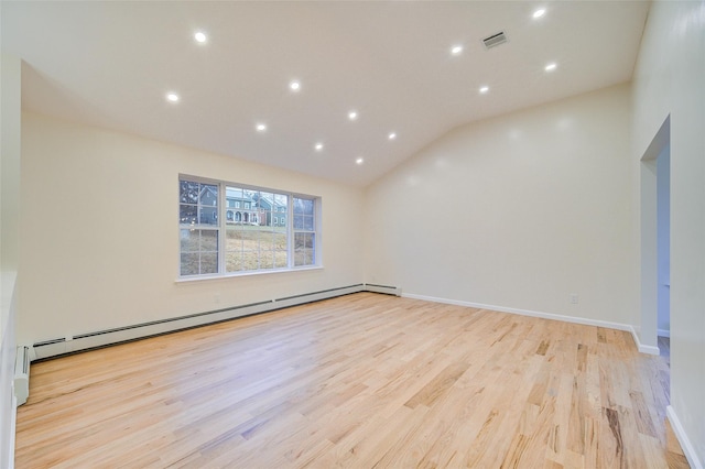 spare room with a baseboard radiator, vaulted ceiling, and light wood-type flooring