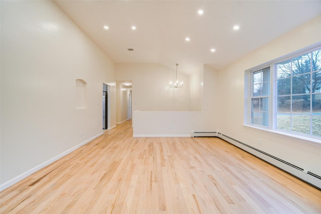 spare room featuring baseboard heating, a chandelier, lofted ceiling, and light hardwood / wood-style floors