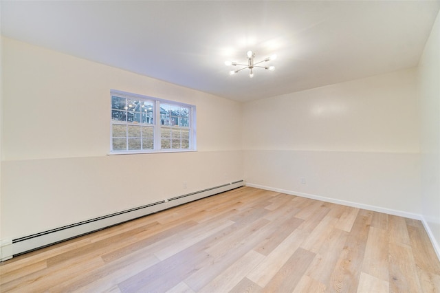 unfurnished room with a baseboard heating unit and light hardwood / wood-style floors