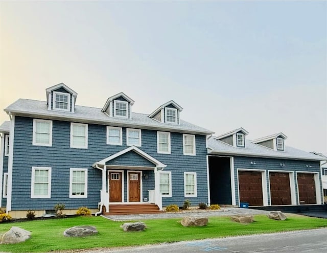 colonial inspired home with a front lawn and a garage