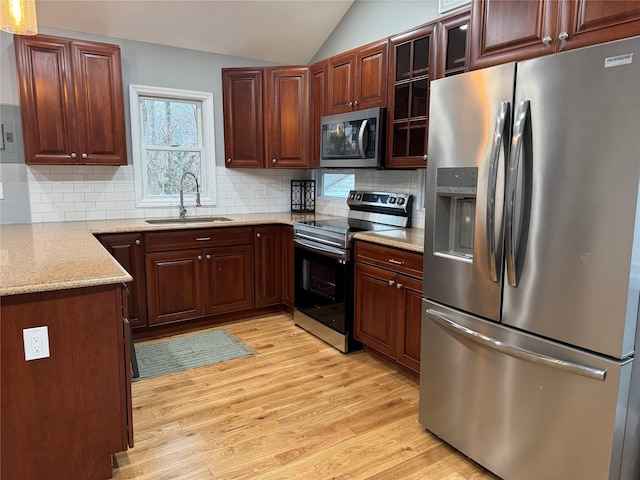 kitchen featuring lofted ceiling, appliances with stainless steel finishes, sink, and tasteful backsplash