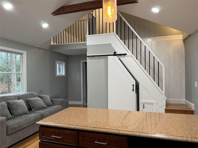 kitchen with high vaulted ceiling, dark brown cabinets, beamed ceiling, and light hardwood / wood-style flooring