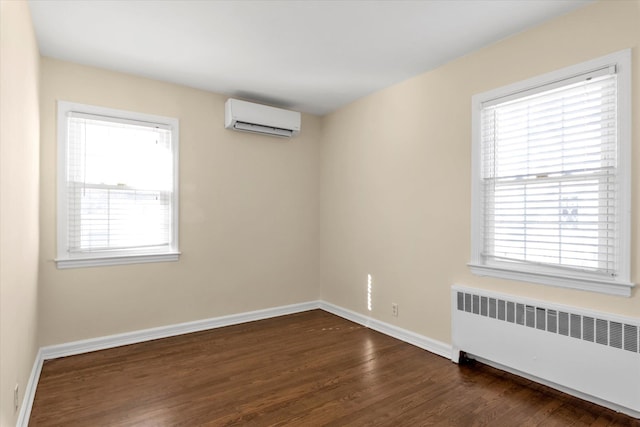 empty room featuring radiator, dark hardwood / wood-style floors, and an AC wall unit