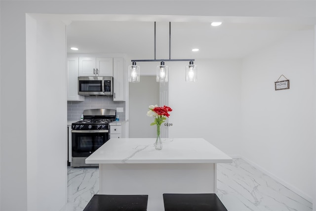 kitchen featuring tasteful backsplash, hanging light fixtures, gas range oven, white cabinets, and light stone counters