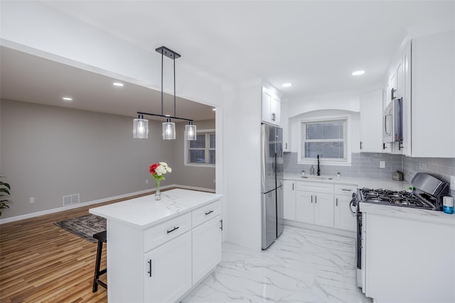 kitchen with white cabinets, appliances with stainless steel finishes, and sink