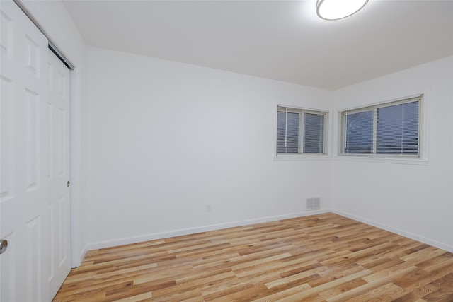 unfurnished bedroom with light wood-type flooring and a closet