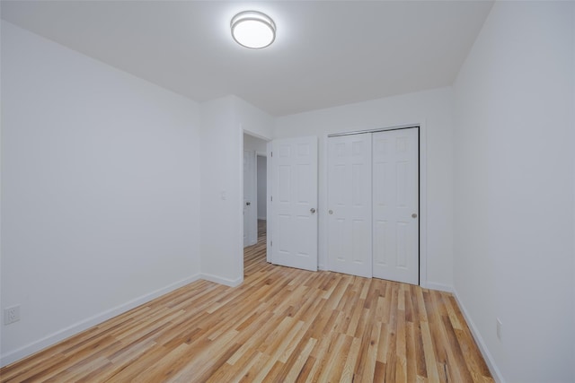 unfurnished bedroom featuring a closet and light hardwood / wood-style flooring