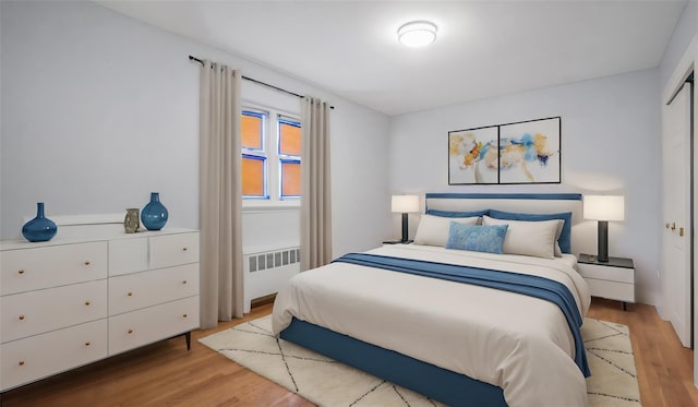 bedroom featuring radiator and light wood-type flooring