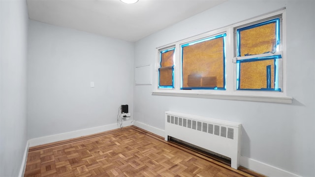 clothes washing area featuring light parquet flooring and radiator