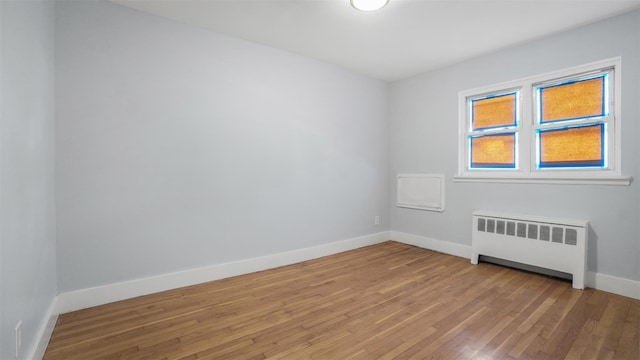 unfurnished room with radiator and light hardwood / wood-style floors