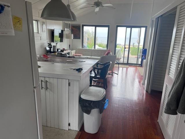 kitchen with lofted ceiling, ceiling fan, fridge, hardwood / wood-style flooring, and white cabinets