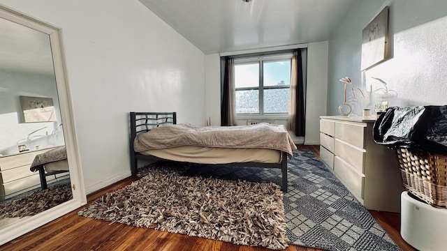 bedroom with vaulted ceiling and dark hardwood / wood-style floors