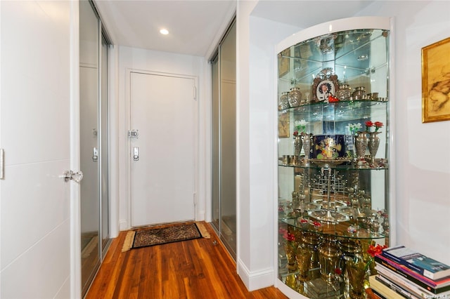 hallway with hardwood / wood-style flooring