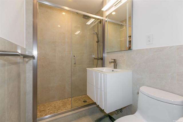 bathroom with tile walls, an enclosed shower, vanity, and toilet