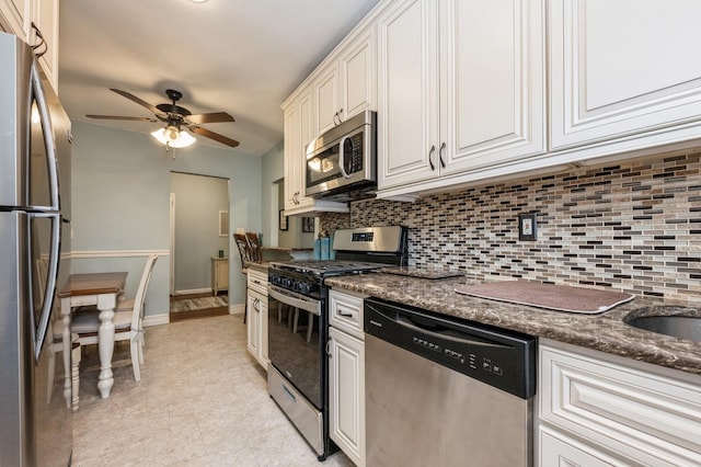 kitchen with ceiling fan, white cabinets, dark stone counters, and stainless steel appliances