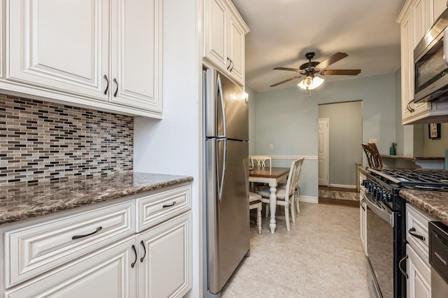 kitchen with stone countertops, white cabinetry, appliances with stainless steel finishes, and ceiling fan