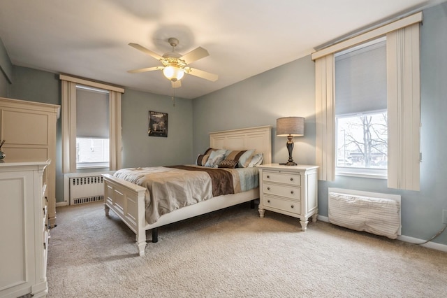 bedroom featuring ceiling fan, light carpet, and radiator heating unit