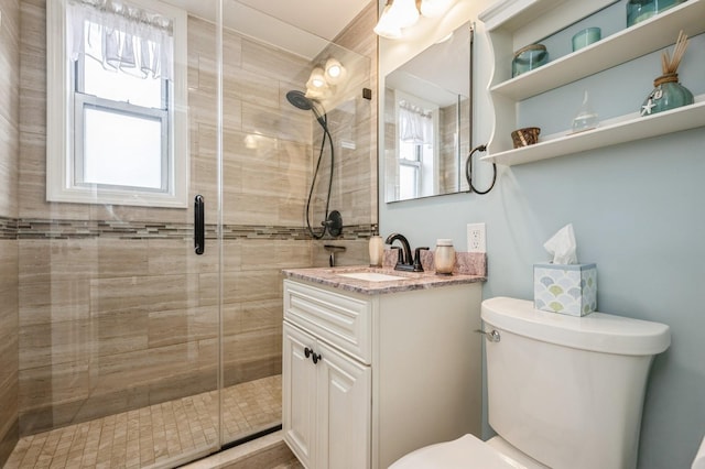 bathroom featuring toilet, walk in shower, and vanity