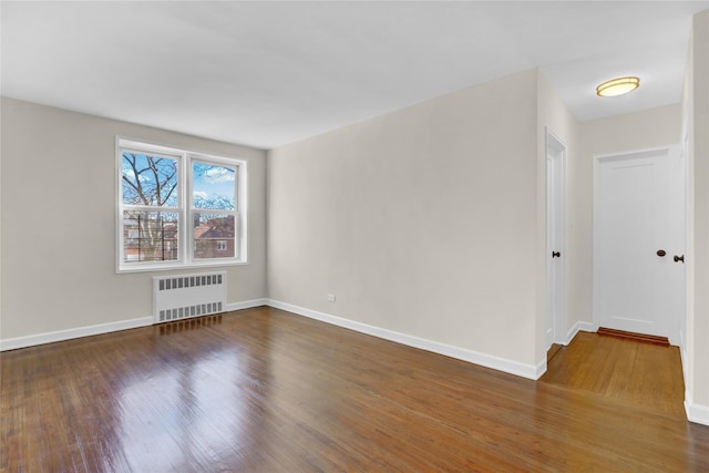 unfurnished room with radiator and dark hardwood / wood-style flooring