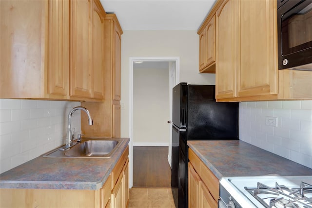 kitchen with decorative backsplash, sink, light brown cabinets, and black appliances