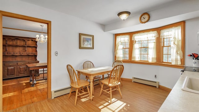 47A Old Squires Rd, Hampton Bays, NY 11946 - dining room featuring baseboard heating, a baseboard radiator, light wood-style flooring, and a chandelier
