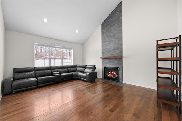 unfurnished living room featuring hardwood / wood-style flooring, high vaulted ceiling, and a fireplace