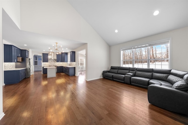 living room with high vaulted ceiling, a notable chandelier, and dark hardwood / wood-style floors