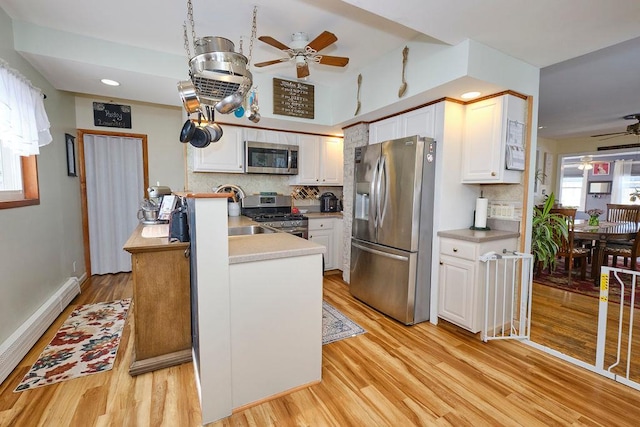 kitchen featuring white cabinetry, stainless steel appliances, and decorative backsplash