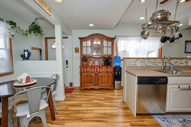 kitchen featuring sink, a healthy amount of sunlight, stainless steel dishwasher, and white cabinets