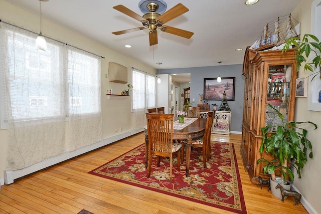 dining area featuring light hardwood / wood-style floors, ceiling fan, and baseboard heating