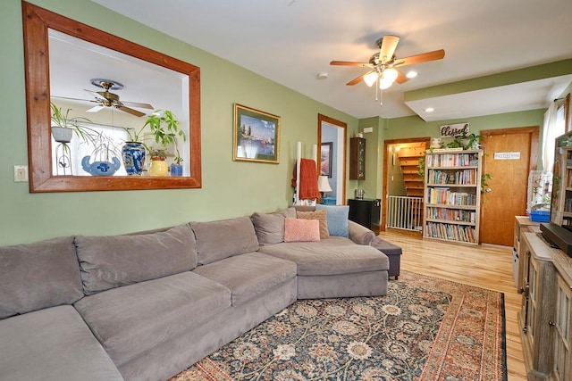 living room featuring light hardwood / wood-style flooring and ceiling fan