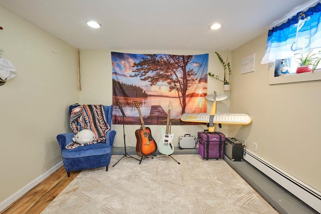 living area featuring baseboard heating and wood-type flooring