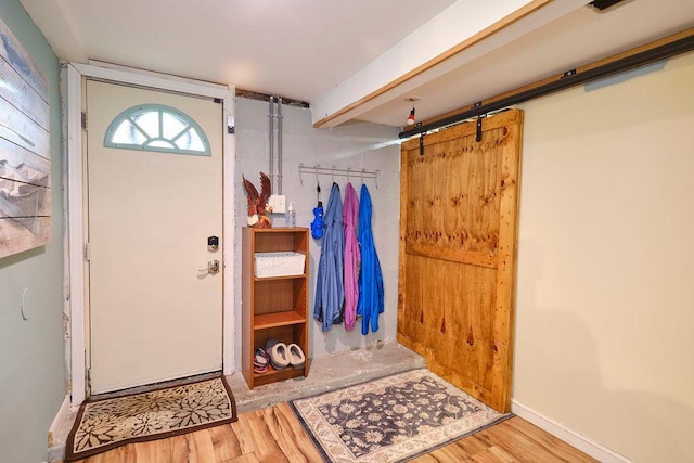 foyer entrance with wood-type flooring and a barn door