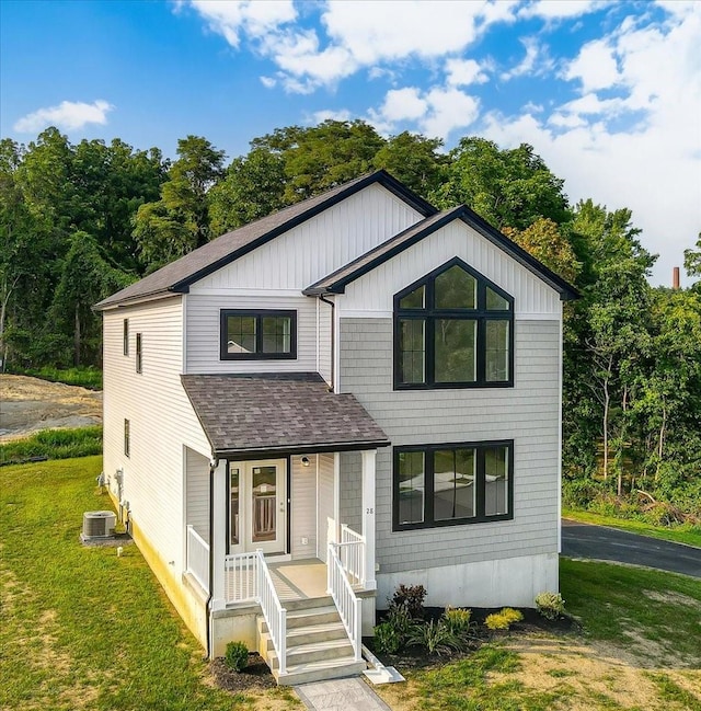 view of front of property with a front lawn and central AC