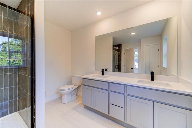 bathroom with walk in shower, vanity, and toilet