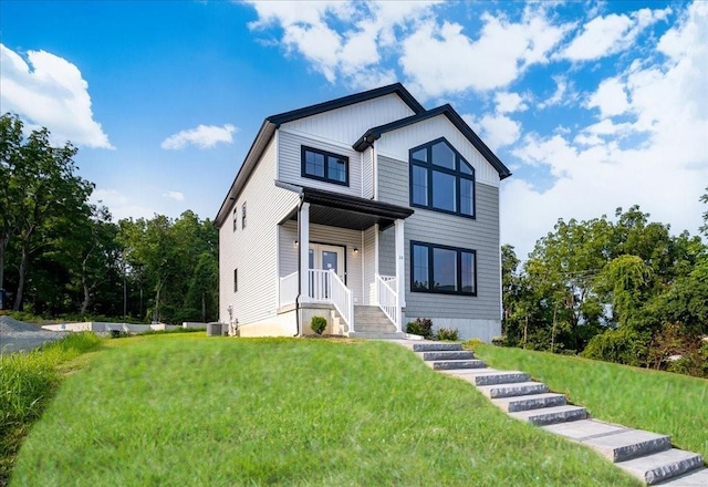 view of front of property with a front lawn and cooling unit