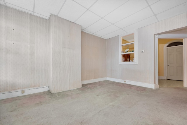 carpeted empty room with a paneled ceiling